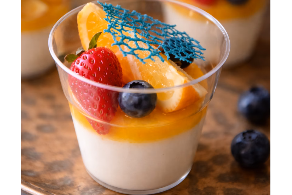 ნაზი პანაკოტა გამჭვირვალე ჭიქებში, გაფორმებული მარწყვით, მოცვითა და ფორთოხლის ნაჭრით – ფურშეტისთვის